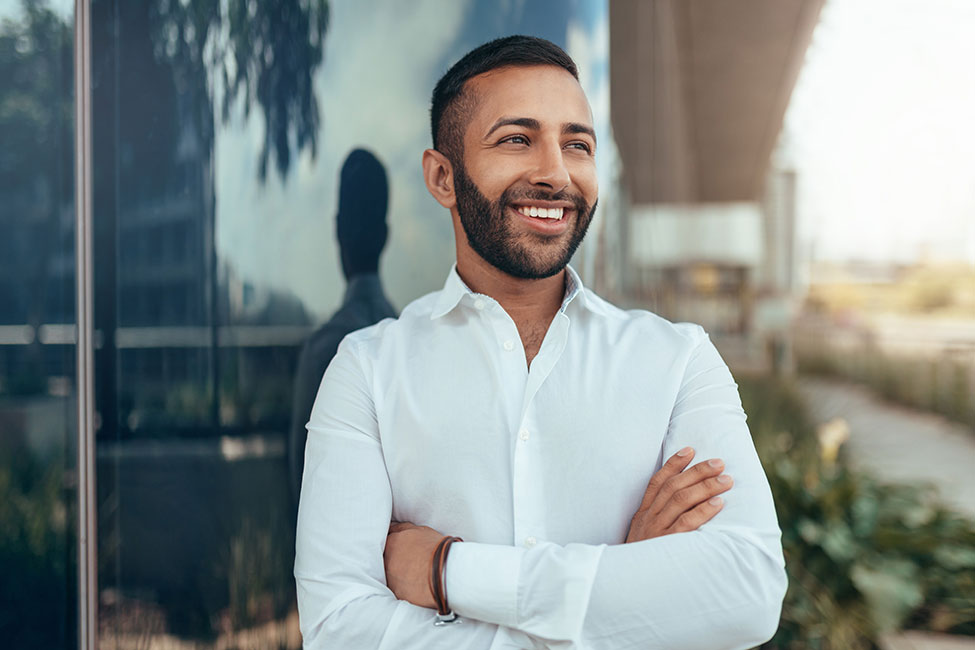 Man in a white button down shirt with his arms crossed