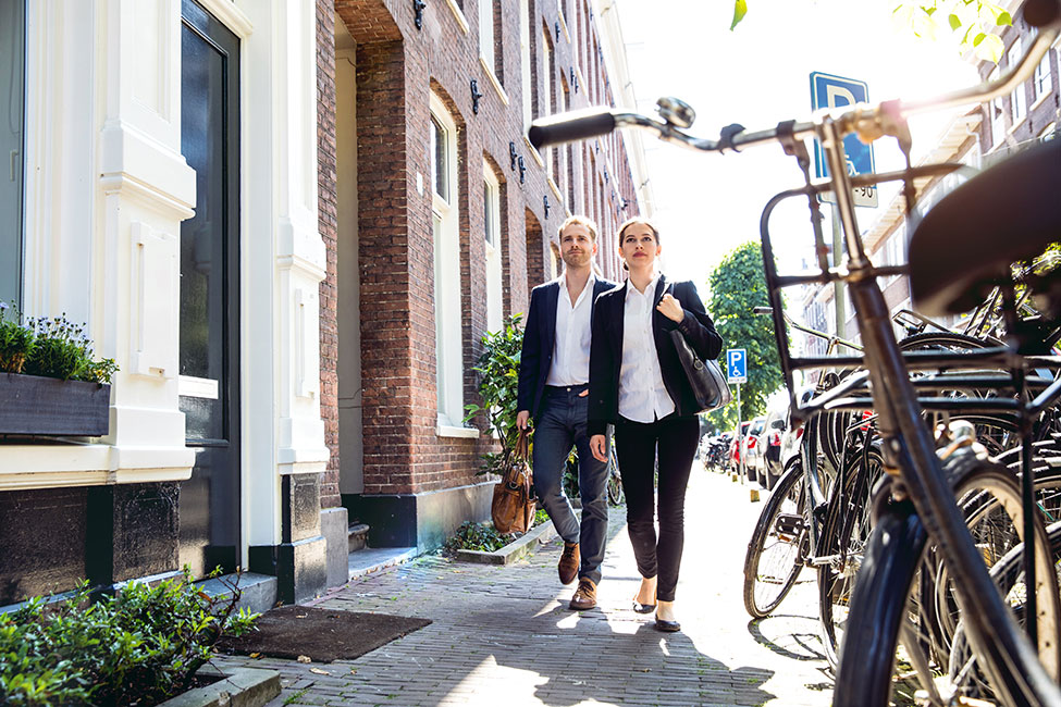 Man and woman colleagues in business clothes walking down the street